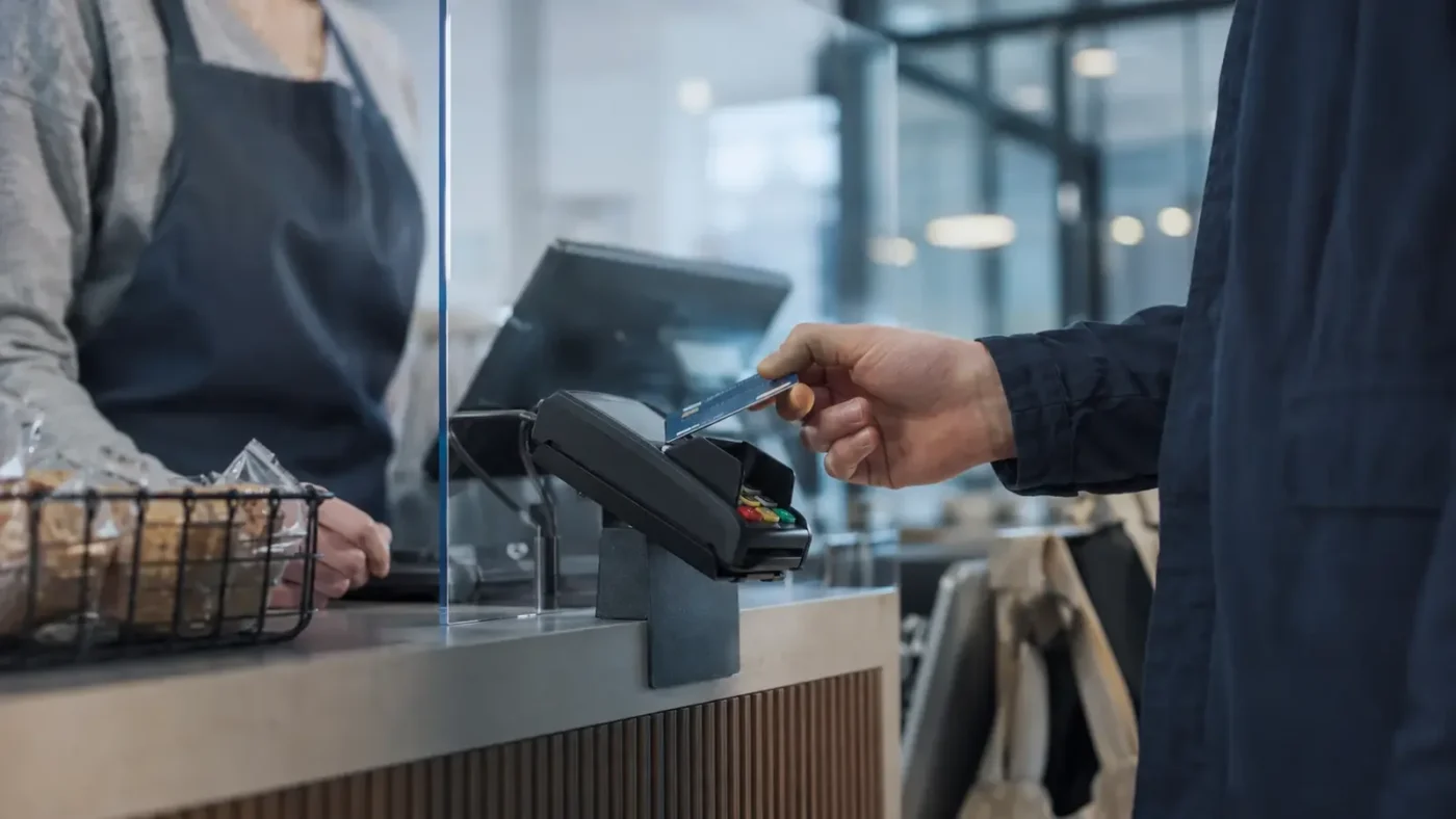 Kundin bezahlt an einem Terminal mit einer Debitkarte